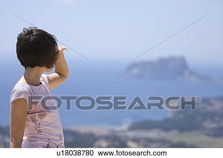 Stock Image - Spain, Costa Blanca, Woman looking at seascape. Fotosearch