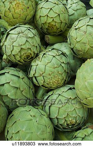 Stock Image - Stack of artichokes on market. Fotosearch