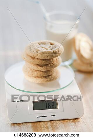 Stock Photo - Stack of cookies on weight scale. Fotosearch