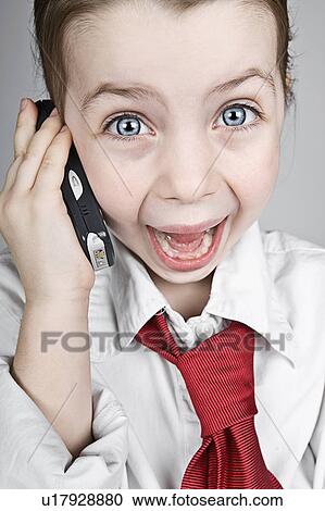 Stock Image - Studio portrait of girl (6-7) dressed-up as businesswoman. Fotosearch