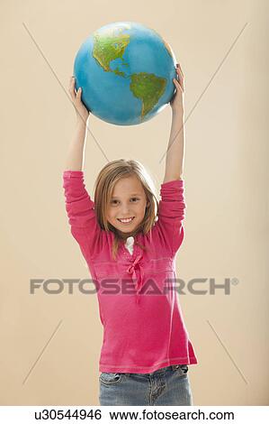 Studio portrait of girl (8-9) holding globe View Large Photo Image Stock Photograph - Studio portrait of girl (8-9) holding globe. Fotosearch
