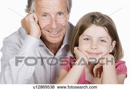 Stock Photo - Studio portrait of senior man with granddaughter (6-7). Fotosearch