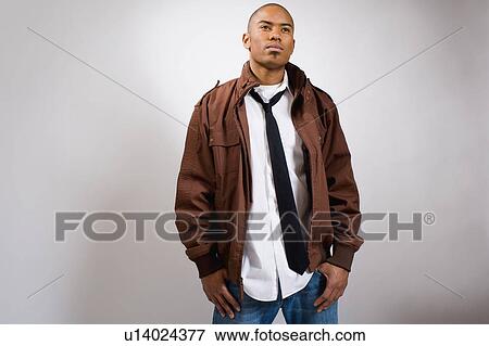 Stock Photo - Studio portrait of young man wearing jacket. Fotosearch