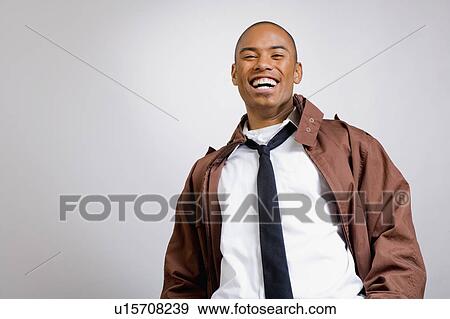 Stock Photo - Studio portrait of young man wearing jacket. Fotosearch
