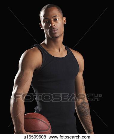 Studio portrait of young man with basketball View Large Photo Image Stock Photo - Studio portrait of young man with basketball. Fotosearch