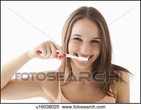 Studio portrait of young woman brushing teeth View Large Photo Image Stock Image - Studio portrait of young woman brushing teeth. Fotosearch
