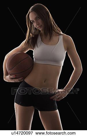 Studio portrait of young woman holding basketball View Large Photo Image Stock Photo - Studio portrait of young woman holding basketball. Fotosearch