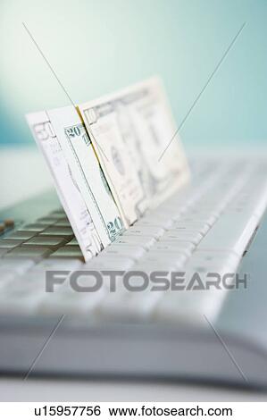 Stock Photograph - Studio shot of banknotes in computer keyboard. Fotosearch