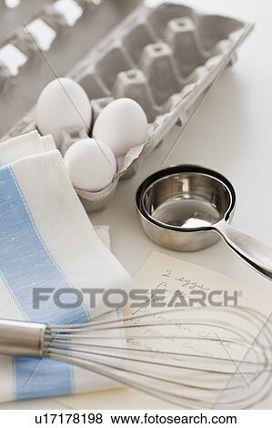Stock Photo - Studio shot of eggs, egg whisk and recipe. Fotosearch