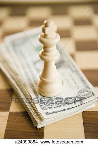 Picture - Studio shot of king chess piece on banknotes. Fotosearch