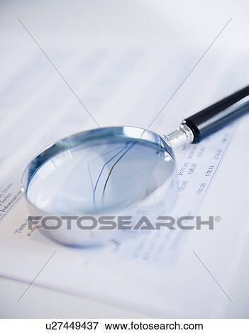 Stock Photo - Studio shot of magnifying glass on document. Fotosearch