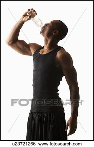 Stock Photograph - Studio shot of man drinking water from bottle. Fotosearch