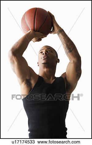 Stock Image - Studio shot of man playing basketball. Fotosearch