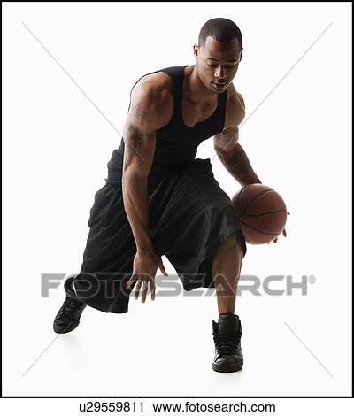Stock Image - Studio shot of man playing basketball. Fotosearch