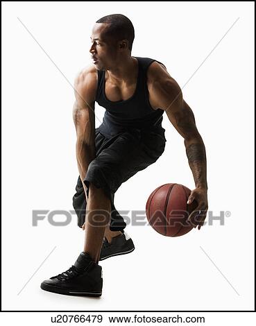 Stock Photo - Studio shot of man playing basketball. Fotosearch