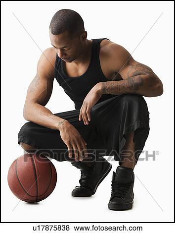 Studio shot of man with basketball crouching View Large Photo Image Stock Photo - Studio shot of man with basketball crouching. Fotosearch