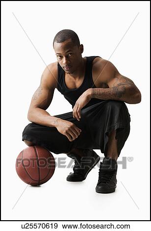 Studio shot of man with basketball crouching View Large Photo Image Stock Photo - Studio shot of man with basketball crouching. Fotosearch