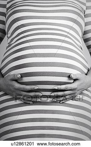 Stock Image - Studio shot of pregnant woman. Fotosearch