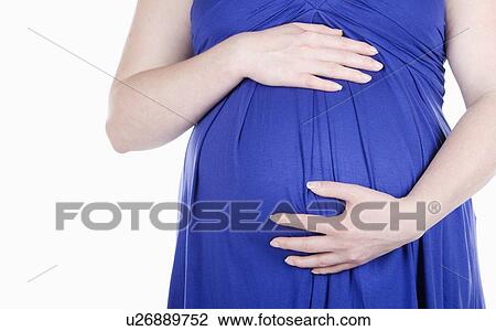 Stock Image - Studio shot of pregnant woman. Fotosearch