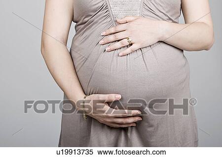 Stock Photography - Studio shot of pregnant woman. Fotosearch