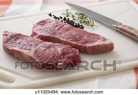 Picture - Studio shot of raw steak on chopping board. Fotosearch