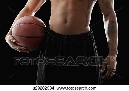 Studio shot of shirtless man holding basketball, mid section View Large Photo Image Picture - Studio shot of shirtless man holding basketball, mid section. Fotosearch