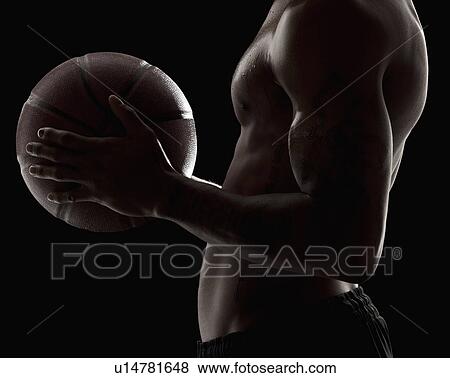 Studio shot of shirtless man holding basketball, mid section View Large Photo Image Stock Photo - Studio shot of shirtless man holding basketball, mid section. Fotosearch