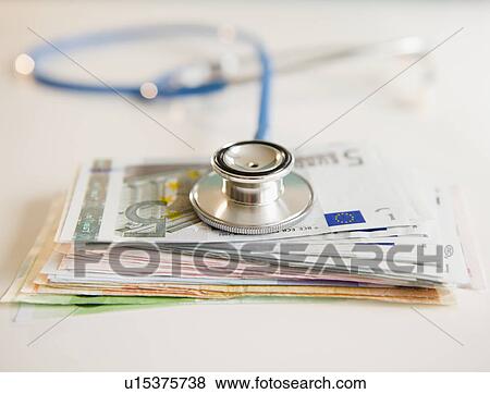 Studio shot of stethoscope on banknotes View Large Photo Image Stock Photo - Studio shot of stethoscope on banknotes. Fotosearch