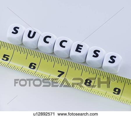 Stock Image - Studio shot of tape measure and dice spelling out success. Fotosearch