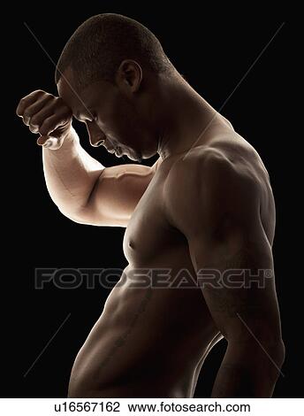 Stock Image - Studio shot of tired shirtless man. Fotosearch