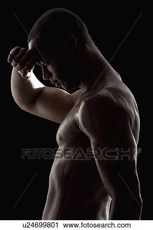 Stock Image - Studio shot of tired shirtless man. Fotosearch