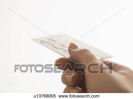 Stock Photography - Studio shot of woman holding credit card. Fotosearch