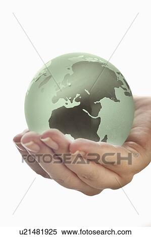 Stock Photography - Studio shot of woman holding glass globe model. Fotosearch