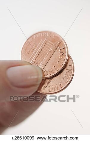 Studio shot of woman holding two one cent coins View Large Photo Image Stock Photo - Studio shot of woman holding two one cent coins. Fotosearch