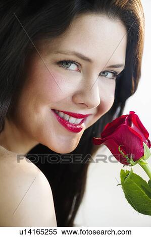 Studio shot of woman smelling red rose View Large Photo Image Stock Photography - Studio shot of woman smelling red rose. Fotosearch