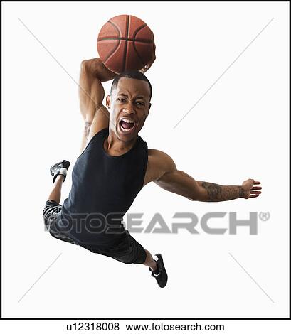Stock Photo - Studio shot of young man playing basketball. Fotosearch
