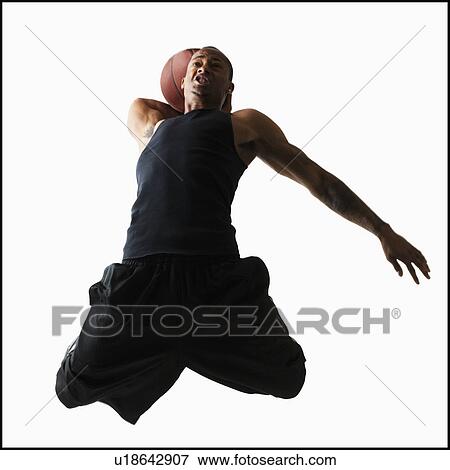 Stock Photo - Studio shot of young man playing basketball. Fotosearch