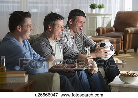 Stock Photo - Three men watching television. Fotosearch