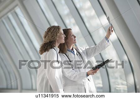 Two doctors examining x-ray View Large Photo Image Stock Photography - Two doctors examining x-ray. Fotosearch