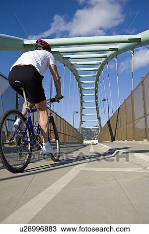 Stock Image - USA, California, Berkeley, Cyclist on bridge. Fotosearch
