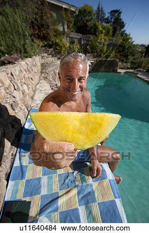 Picture - USA, California, Oakland, Senior man relaxing at swimming pool. Fotosearch