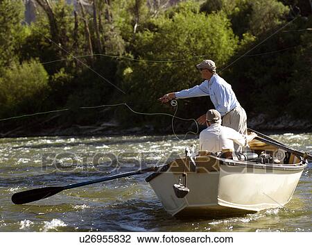 Stock Image - USA, Colorado, Pair of men fly-fishing. Fotosearch