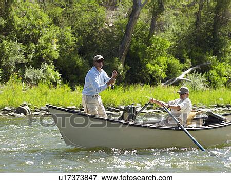 Stock Photo - USA, Colorado, Pair of men fly-fishing. Fotosearch