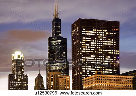 Stock Photograph - USA, Illinois, Chicago, Illuminated skyscrapers at dusk. Fotosearch