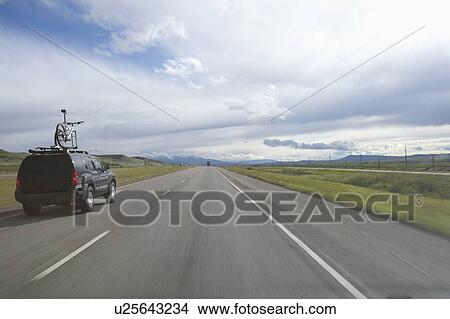 Picture - USA, Montana, Car driving down rural highway. Fotosearch