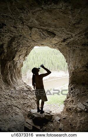 USA, Montana, Smith River, Young man drinking water in cave View Large Photo Image Stock Photograph - USA, Montana, Smith River, Young man drinking water in cave. Fotosearch