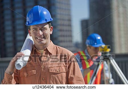 USA, New Jersey, Jersey City, portrait of construction worker holding rolled up blueprint View Large Photo Image Picture - USA, New Jersey, Jersey City, portrait of construction worker holding rolled up blueprint. Fotosearch