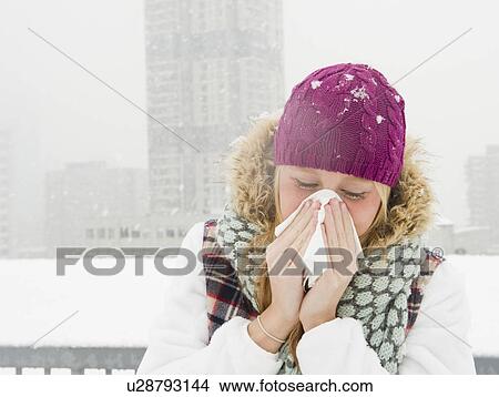 Picture - USA, New Jersey, Jersey City, woman blowing nose. Fotosearch