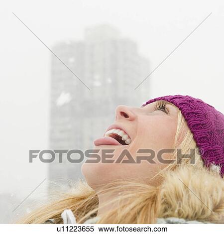 USA, New Jersey, Jersey City, woman catching snowflakes with tongue View Large Photo Image Stock Photography - USA, New Jersey, Jersey City, woman catching snowflakes with tongue. Fotosearch