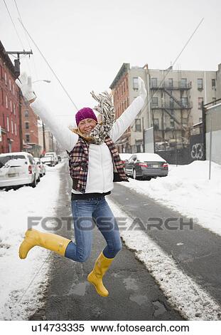 Stock Photography - USA, New Jersey, Jersey City, woman jumping on street. Fotosearch